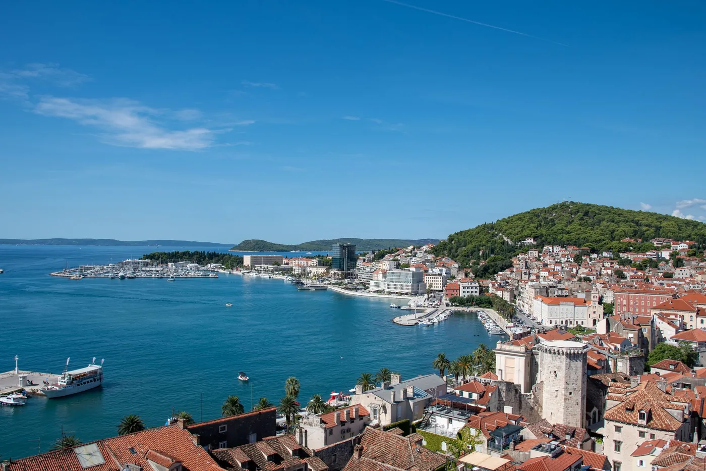 Der Hafen und die roten Dächer von Split von oben, unter einem bewaldeten Hügel