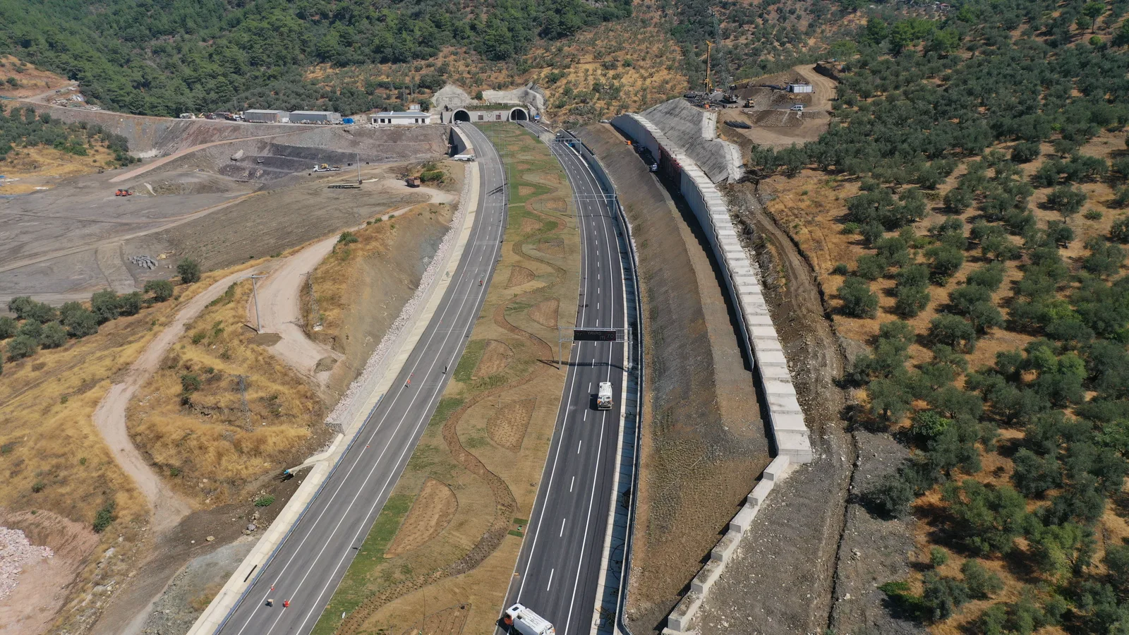 Twin tunnel portals where a motorway runs through karst hills